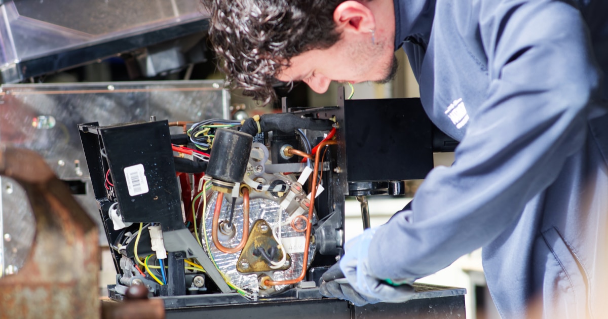 Technicien Mathieu Paris réparant le circuit électrique d'une machine à café professionnelle